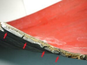 Close-up view of the “A” side axial fracture surface approximately 8 inches. (20 cm) from the tank bottom reveals black oxide covered arc-shaped crack fronts (arrows) indicating pre-existing cracks in the fracture surface. 