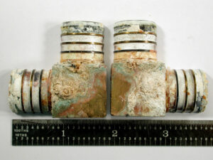 The above image shows the two brass elbow plumbing fittings in the received condition for analysis. Significant deposits and various stains were observed on the outer surface of the fittings. 
