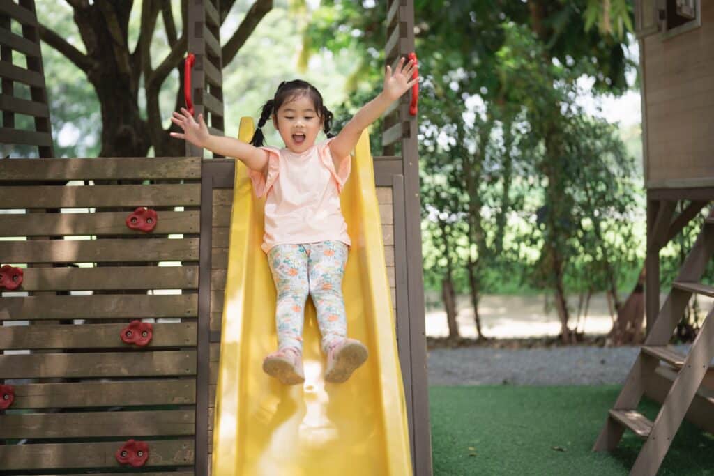 Asian,Little,Girl,Is,Sitting,On,A,Green,Slide

Child and Adolescent Safety playground