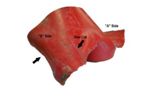 View of the cut-off cylinder bottom on the “B” side. The black arrow identifies an area where the fracture surface is shown in a close-up view in Figure 8. 