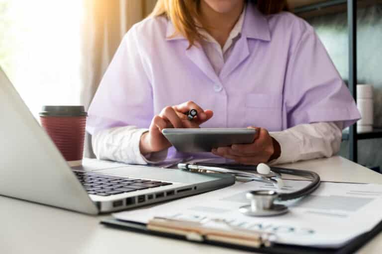 The doctor is working on a tablet and audio player and a digital tablet computer in a modern office with coffee in the morning at the desk. Formative Usability Testing