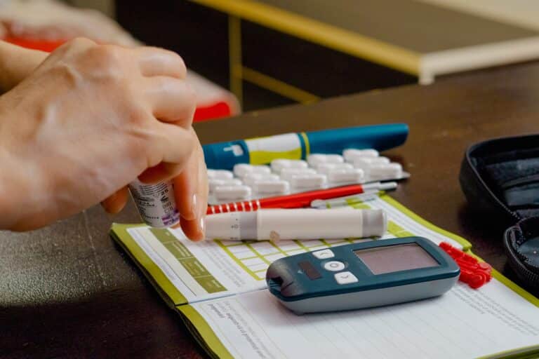 Labeling Comprehension Studies A woman prepares to monitor her blood sugar levels by inserting a test strip into a glucometer at home. This helps in managing her diabetes effectively.