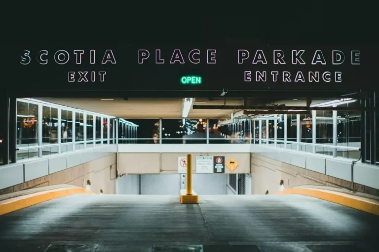 The image shows a nighttime view of the illuminated entrance and exit to the Scotia Place Parkade.