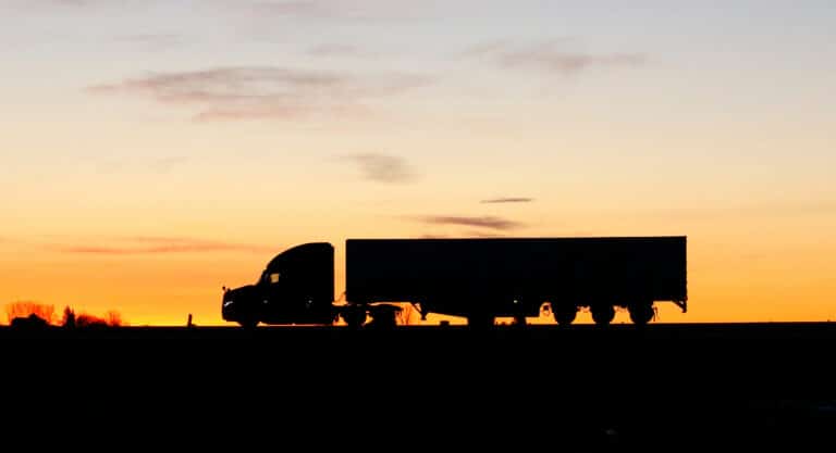 Semi tractor-trailer traveling on a US interstate highway at dusk